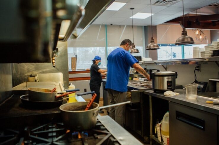 People Cooking in a dinner, with masks