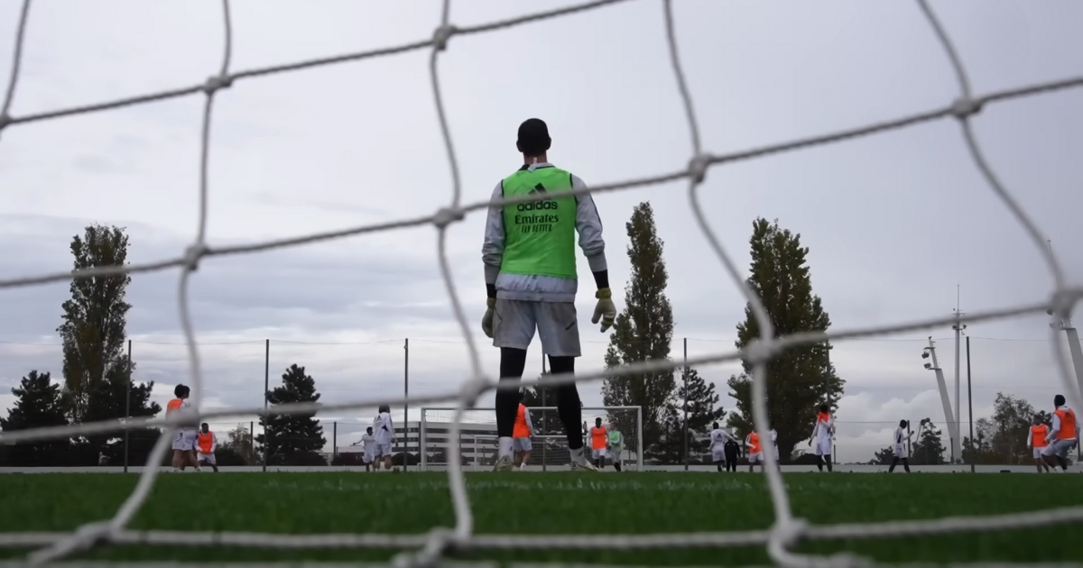 Goalkeeper standing in front of a goal playing soccer