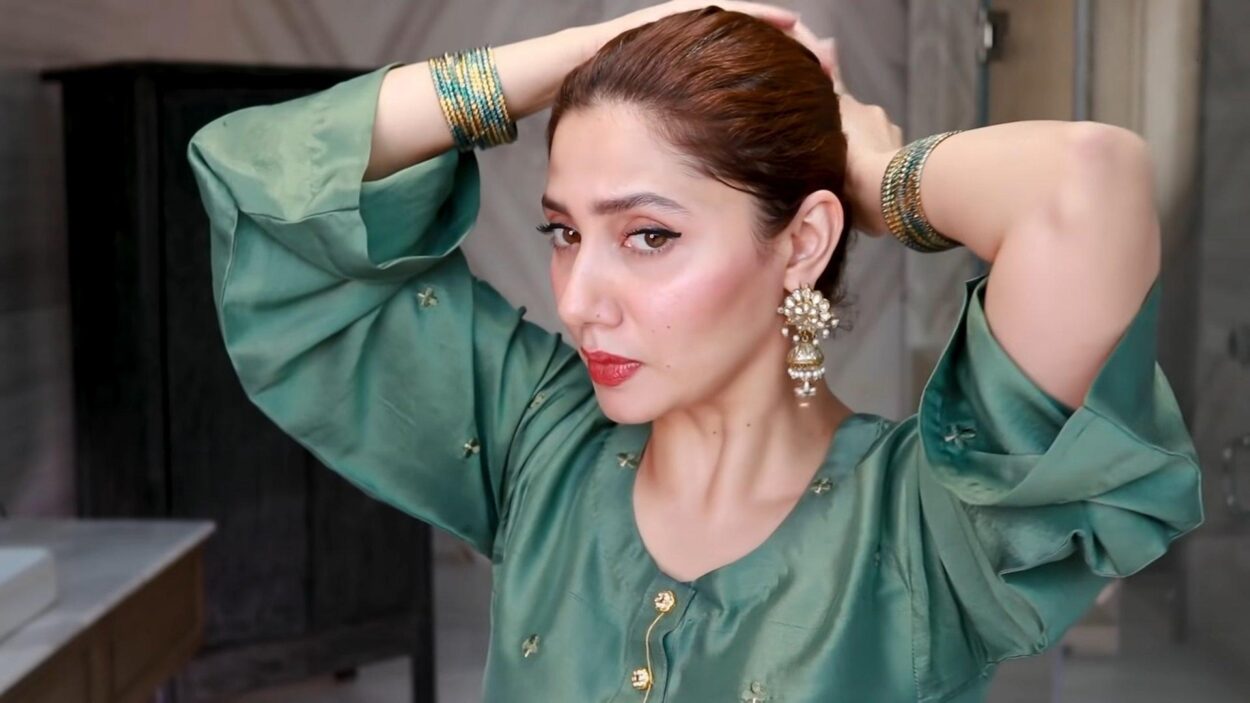Woman wearing a green traditional outfit with gold earrings and bangles
