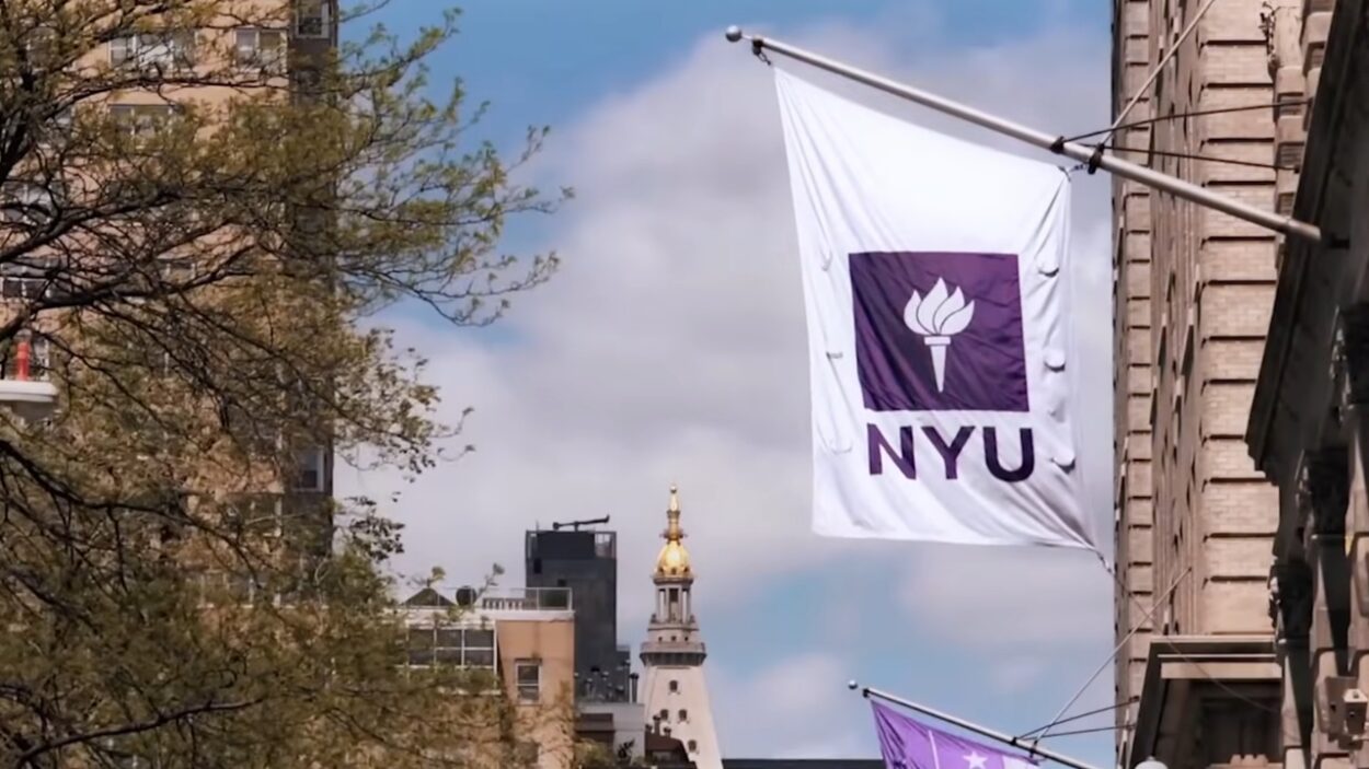 NYU flag displayed above a Manhattan street near the university campus.