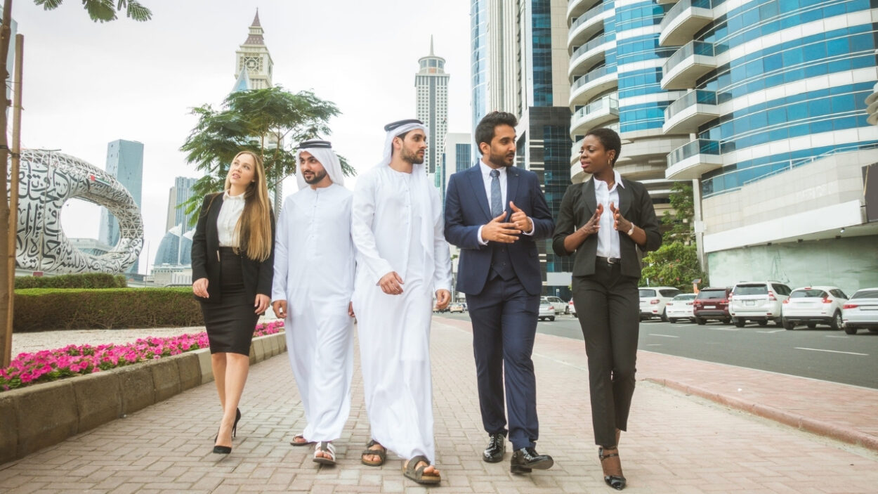Business professionals walk through Dubai’s financial district